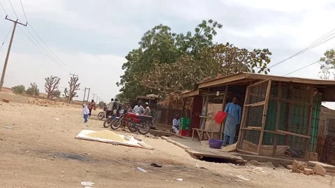Man Winnowing Maize By Roadside With Okada Parked Kano Nigeria 動画素材 329485504