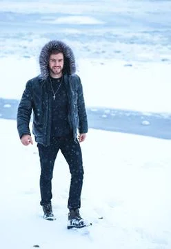 A man in winter on a background of snow in black clothes Stock Photos