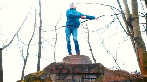 A man in winter clothes makes a dance movement floss on a hill. Stock Footage 124065786