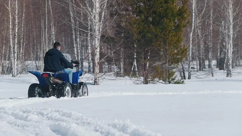 A man in winter clothes riding snowmobile in the forest Stock Footage 106871558