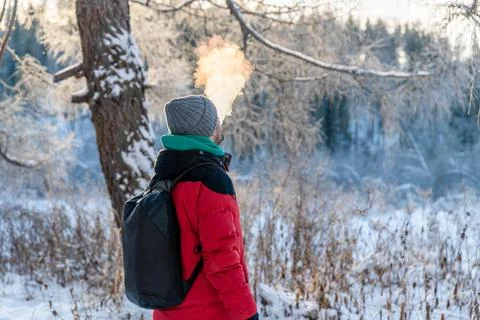 A man in the winter in the cold exhales a cloud of steam, smoke Foto stock