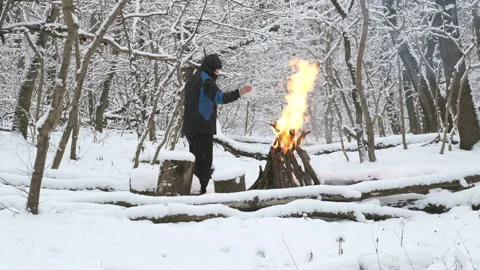 Man in the winter forest kindles a fire Stock Footage 168926678