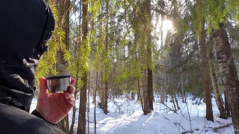 The man in the winter in the forest pours tea from a thermos. Stock Footage 104962184