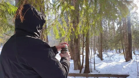 The man in the winter in the forest pours tea from a thermos. Stock Footage 104962395