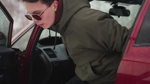 Man in Winter Jacket Steps Out of Car with Snowflakes Falling Around Vidéo 310178664