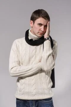 Man in winter knitted clothes standing with arms folded isolated on gray Stock Photos