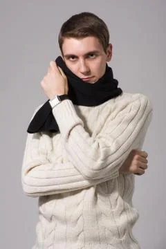 Man in winter knitted clothes standing with arms folded isolated on gray Stock Photos