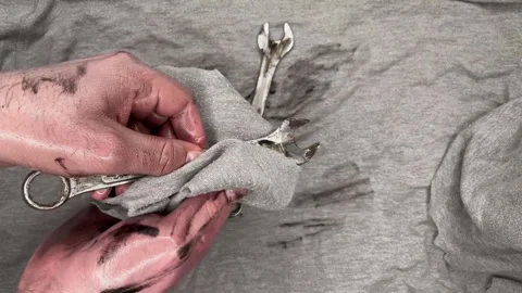 A man wipes chrome vanadium wrenches from oil and lays them out on a gray rag. Stock Footage 304237910