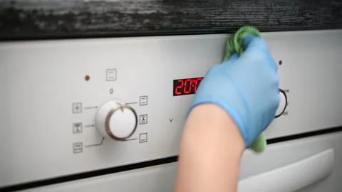 A man wipes the glass control panel of an oven in the kitchen. Video stock 300080897