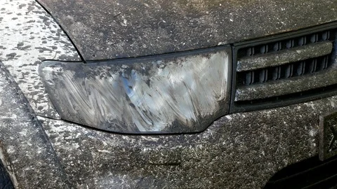 A man wipes a very dirty headlight of a dirty SUV with a napkin. Hand close up Stock Footage 130062218