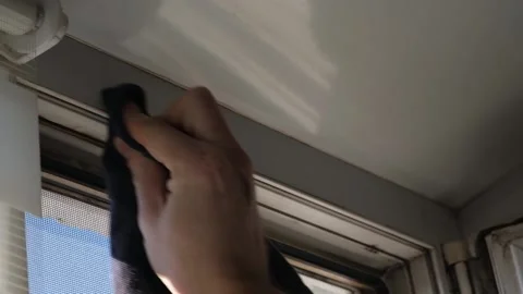 Man wipes window frame with a degreaser and glues a sealing rubber tape on it Stock Footage 235676502