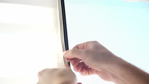 Man wipes window frame with a degreaser and glues a sealing rubber tape on it Stock Footage 235676572