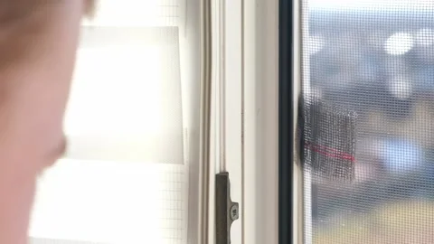 Man wipes window frame with a degreaser and glues a sealing rubber tape on it Stock Footage 235914023