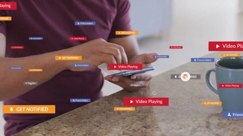 Man wiping phone in kitchen while play button appearing and generating tech tags Stock Footage 333818425