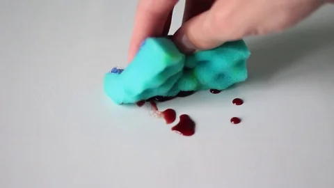 Man wiping red drops with a sponge Видео 71951882
