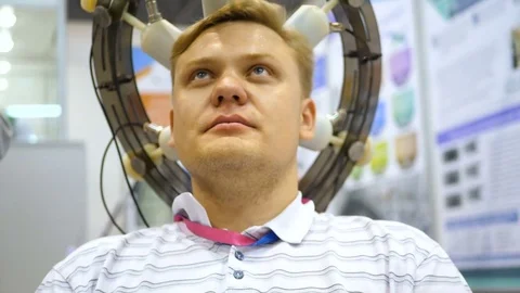 Man wired to an EEG machine or electroencephalograph which produces a graphical Stock Footage 81518935