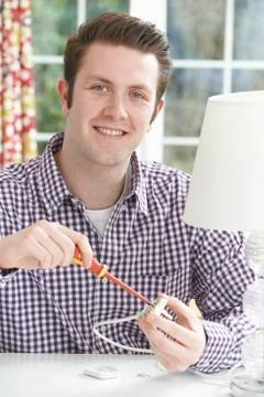 Man Wiring Electrical Plug On Lamp At Home Stock Photos