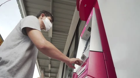 Man withdraw cash from ATM with face mask for plague corona virus. Stock Footage 133545409