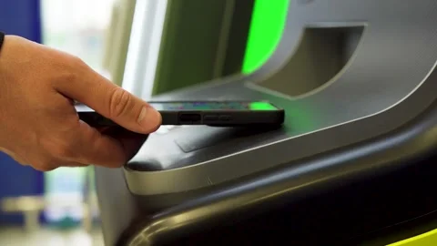 A man withdraws money from an ATM using his cell phone through an NFC terminal Stock Footage 279536352