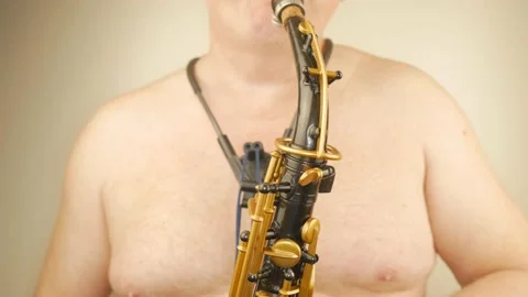 A Man Without Clothes Playing An Old Saxophone Stock Footage 153370053