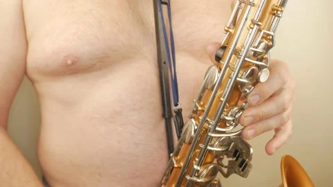 A Man Without Clothes Playing An Old Saxophone Stock Footage 153370055