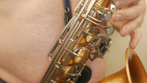 A Man Without Clothes Playing An Old Saxophone Stock Footage 153370065