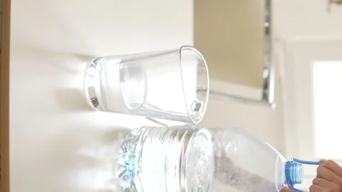 A man without a face pours drinking water from a large bottle into a carafe. Stock Footage 234503630