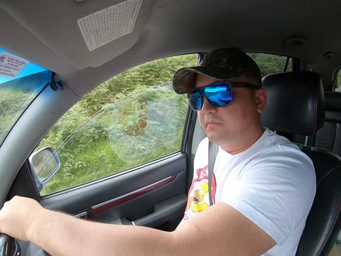 Man without a hand in blue sunglasses driving the car. Stock Footage 151646338