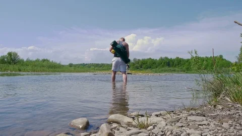 Man without shoes goes through the shallow water on the river Stock Footage 102913165
