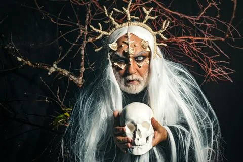 Man wizard with skull. Devil horror concept. Bearded old man dressed like 스톡 사진