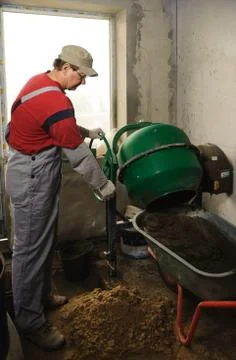 Man woker puts a ready solution in a wheelbarrow Stock Photos