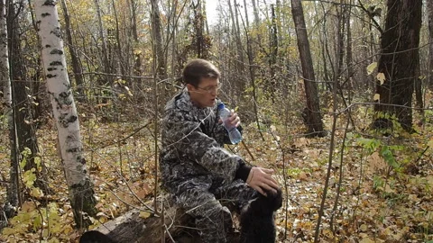 A man in the woods walking with a dog. Stock Footage 95734729