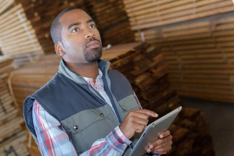Man in woodyard using touchscreen tablet Stock Photos