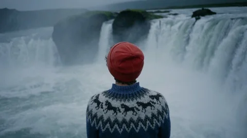 Man in wool sweater on edge of waterfall rock Stock Footage 117415142