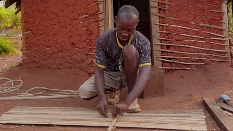 Man at work builds door with bamboo Stock Footage 107309680