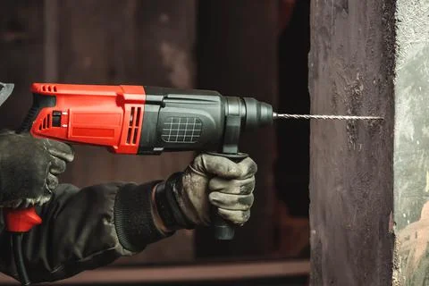 Man at work, drilling hole with big driller to a wall Stock Photos