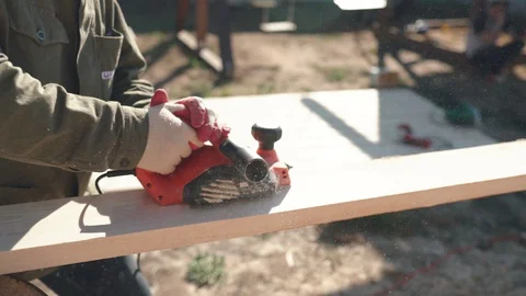 A man work with electric cutting machines. A man planed wood, building house Stock Footage 130047385