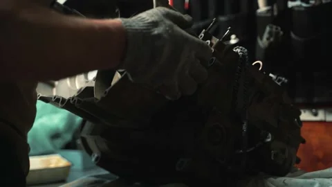 A man in work gloves installs a variator box on an ATV engine Vidéo 159984664