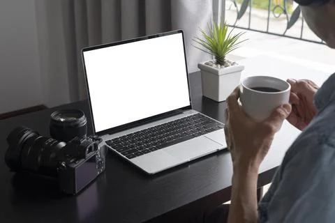 A man work at home and drinking a cup of coffee and using a laptop computer Stock Photos