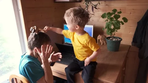 Man work at home, child with cat plays near and hinder, parenthood multitasking Video stock 130494673