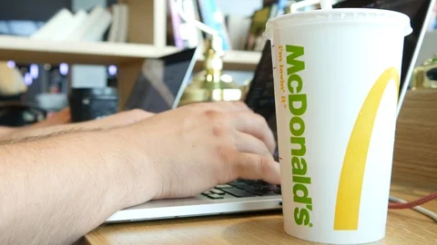 Man work on Laptop in Office, drinks Soda Cola from McDonald's Paper Cup Video stock 109530902