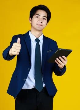 Man work on notepad. Right thumbs up to cheerful people. Studio shoot with .. Stock Photos