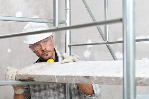Man work, professional construction worker  with scaffolding, safety hard hat Stock Photos