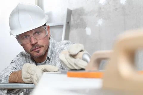 Man work, professional construction worker  with plastering tools on scaffold Stock Photos
