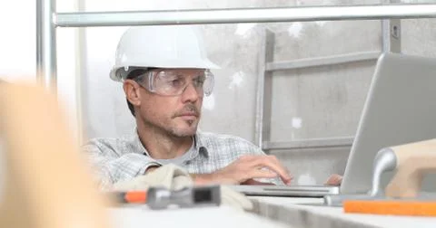 Man work, professional construction worker  with computer, plastering tools o Stock Photos