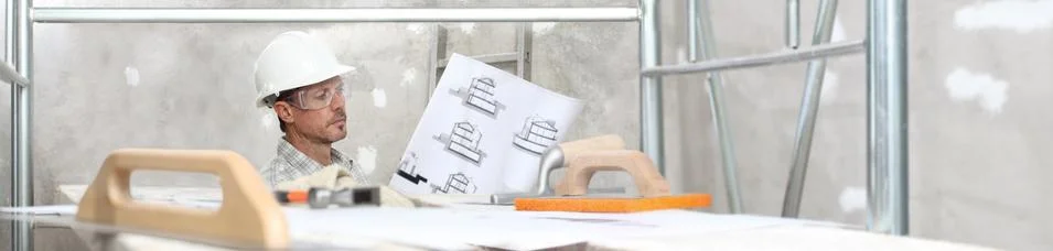 Man work, professional construction worker looking at blueprints on interior  Stock Photos