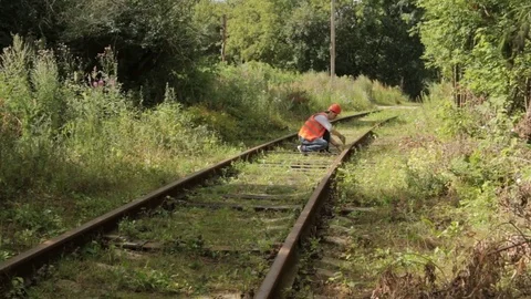 A man work on the railway with a wrench in hand. Video stock 79028633