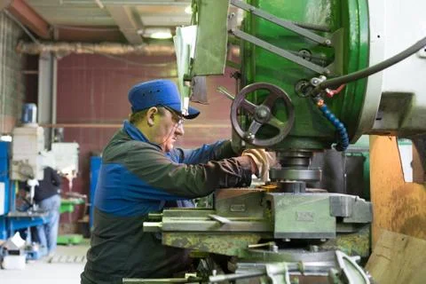 A man at work on a vertical milling machine. Machining of a metal part on a Stock Photos