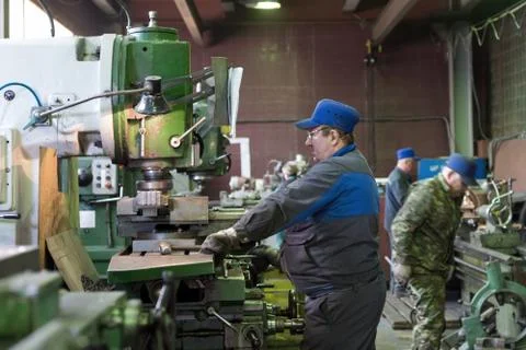 A man at work on a vertical milling machine. Machining of a metal part on a Stock Photos