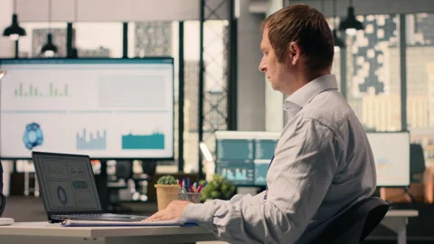 Man worker analyzing KPI metrics and performance review data in corporate office Stock Footage 329328440
